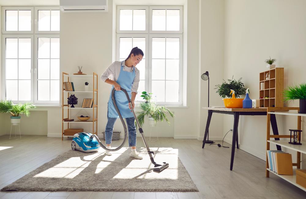 Person vacuuming a carpet room