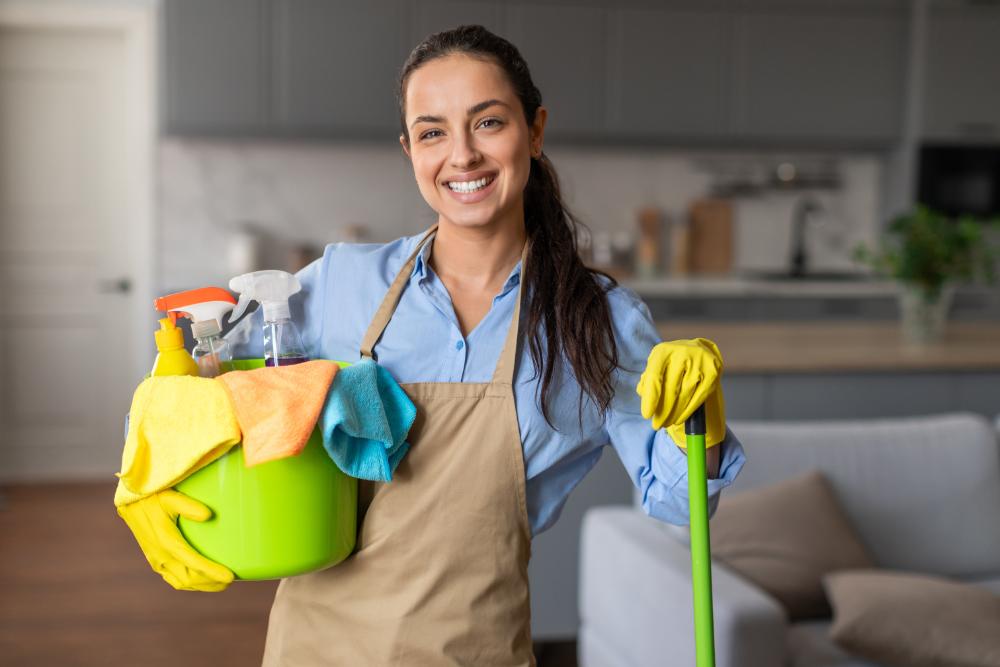 Smiling woman with cleaning supplies